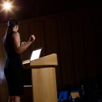 Female business executive giving a speech at conference center
