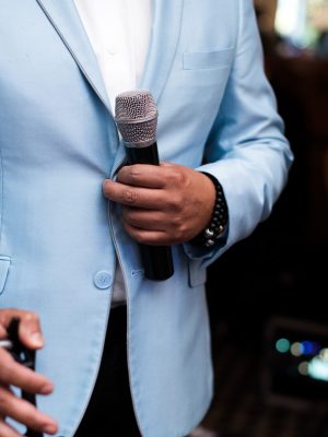 Man in blue suit holds a microphone