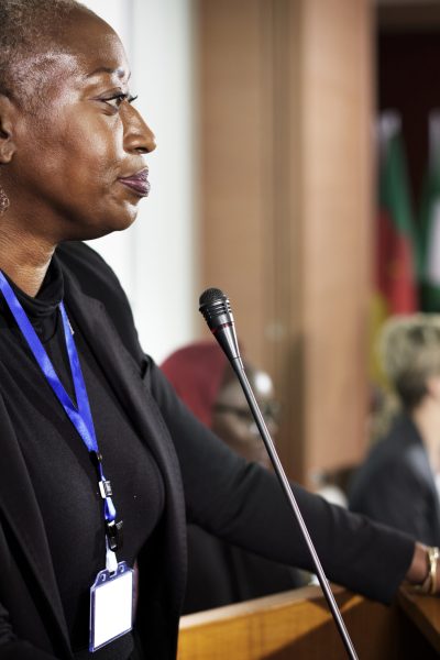 A Middle African Descent Woman Speaking into a Microphone